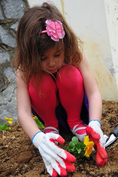 Osan Girl Scouts honored Arbor day/Earth Day by planting 200 yellow pansies and 10 evergreen trees here April 21.  Before the planting, each scout received a brief on the history behind Arbor/Earth Day and the importance of its celebration. The flowers and trees were planted near the elementary school's drop off zone.  (U.S. Air Force photo/Staff Sgt. Daylena Gonzalez)