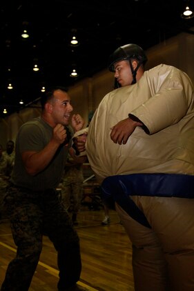 Sgt. Enrique D. Watson, a Headquarters and Headquarters Squadron competitor, demonstrates a tactical grabbing manuever to Lance Cpl. Seth P. Stringham, an H&HS competitor, during the 2011 Commander’s Cup Sumo Basho at the IronWorks Gym sports courts here April 22. The Sumo Basho is one of the nine Commander’s Cup events held throughout the year.