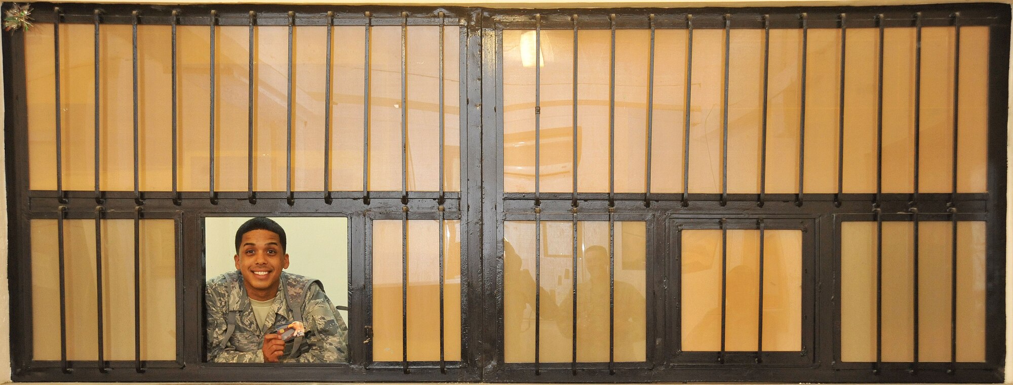 Senior Airman Jon-Nicos Walker, Air Force Financial Management Detachment 2 military pay technician, poses for a photo in the cashier’s cage April 12, 2011, at Contingency Operating Site Marez, Iraq. Airman Walker is deployed from the 319th Comptroller Squadron at Grand Forks Air Force Base, N.D. (U.S. Air Force photo by Senior Airman Andrew Lee/Released)