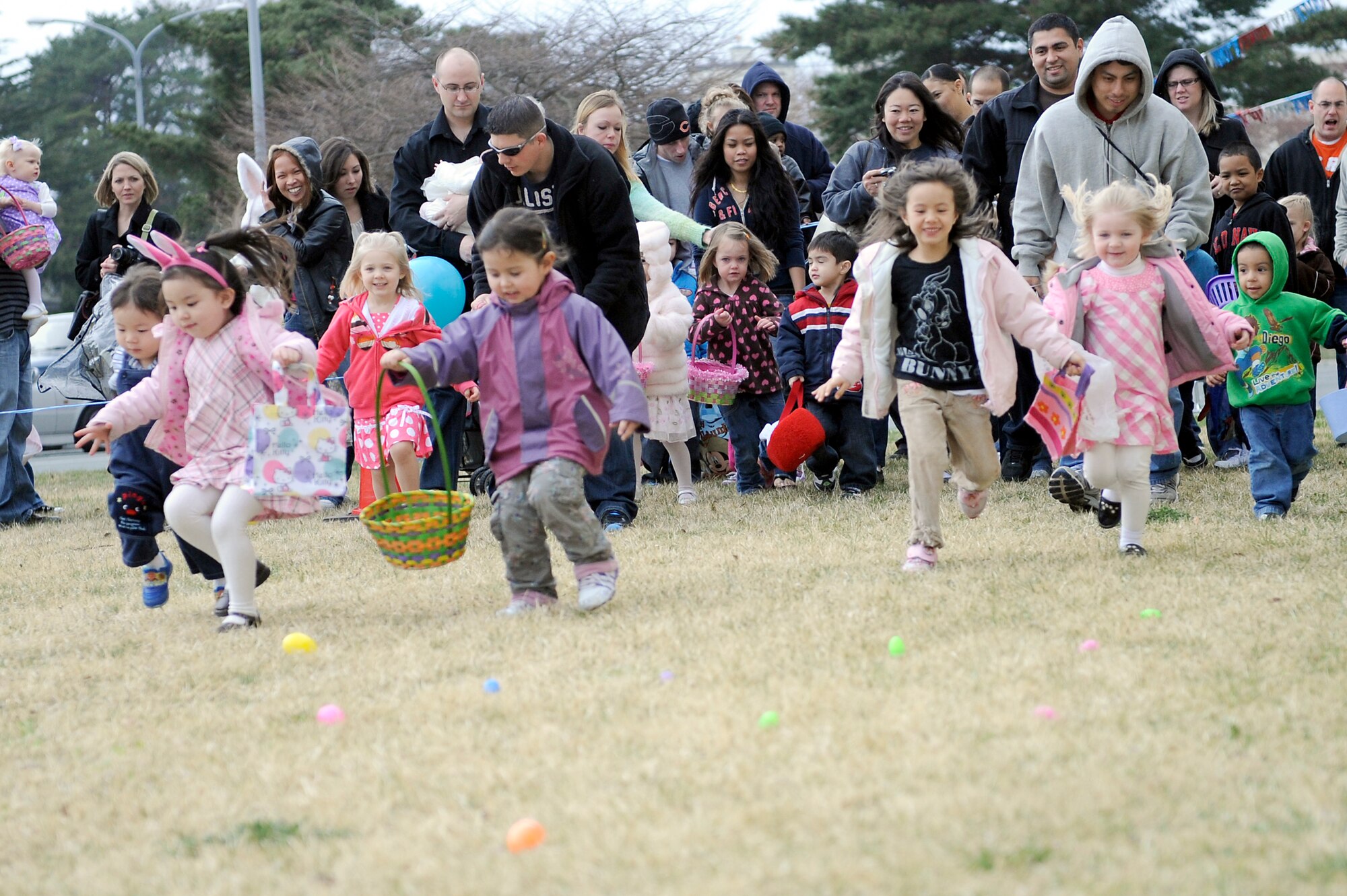 MISAWA AIR BASE, Japan -- Taking off with parents in tow, children rushed to grab eggs scattered in the field beside the Base Exchange near the new car sales during an Easter egg hunt 23 April. Children hunted for plastic eggs full of goodies donated by the Base Exchange. (U.S. Air Force photo by Staff Sgt. Marie Brown\Released)