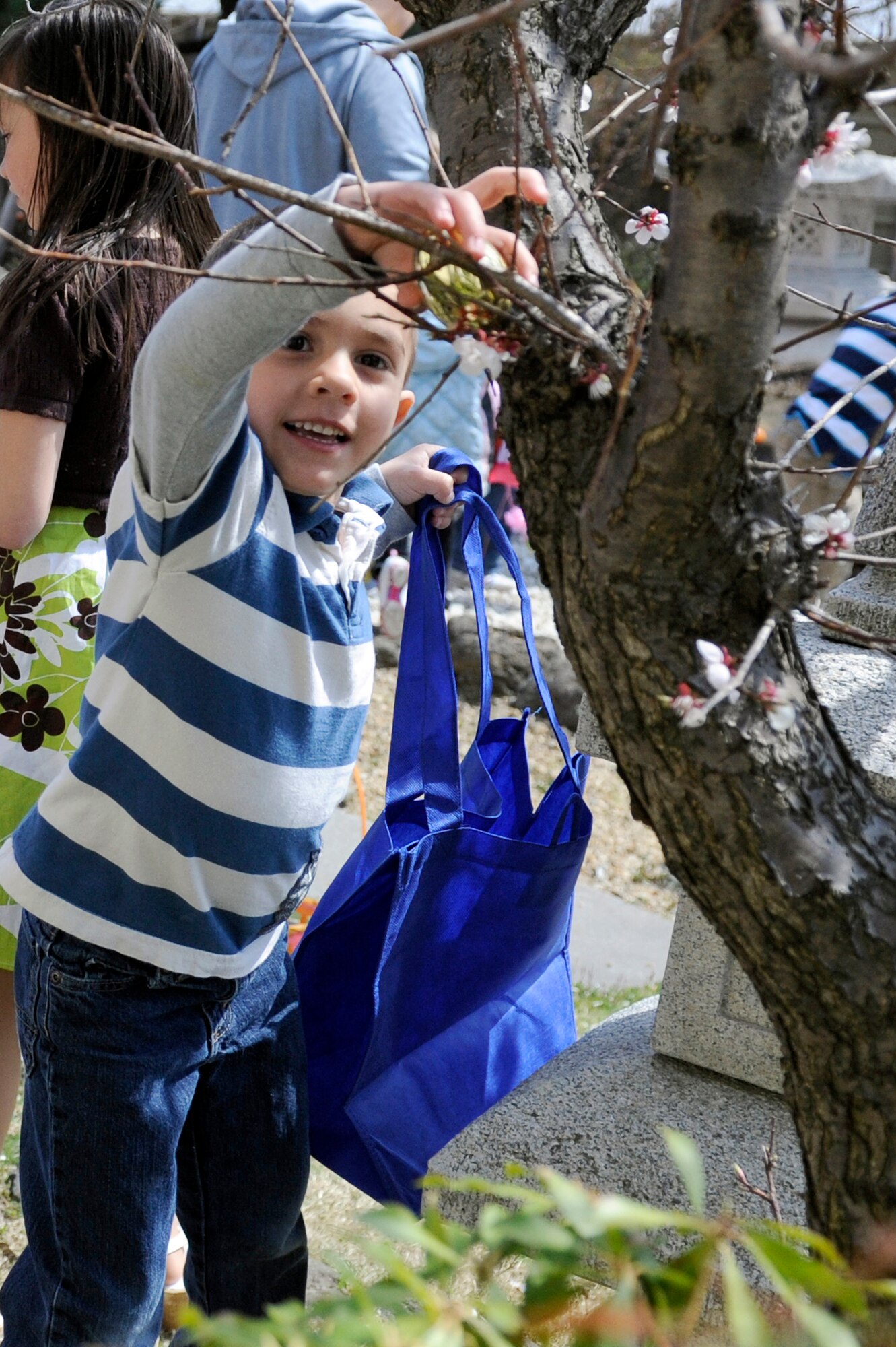 MISAWA AIR BASE, Japan -- Five-year-old Marcos Bravo, son of Tech. Sgt. Leonard Bravo, 35th Operations Support Squadron, collects a golden egg 24 April. Three golden eggs were hid in each age group giving each child that found one an Easter basket full of candy and toys. (U.S. Air Force photo by Staff Sgt. Marie Brown\Released)