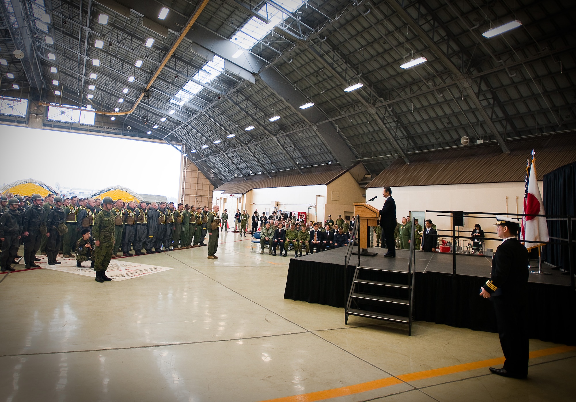 YOKOTA AIR BASE, Japan -- Toshimi Kitazawa, Japan Minister of Defense, speaks at Hangar 15 here April 23. Minister Kitazawa visited Yokota Air Base to thank U.S. service members for their efforts in support of Operation Tomodachi and to observe a bilateral demonstration of U.S. Marine and Japan Ground Self Defense Force chemical response forces. (U.S. Air Force photo/Staff Sgt. Chad C. Strohmeyer)