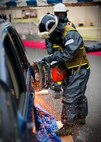 YOKOTA AIR BASE, Japan -- A Marine with the initial response force, demonstrates how to cut into a vehicle at Hangar 15 here April 23. The demonstration was to show Toshimi Kitazawa, Japan Minister of Defense, the team's capability to provide emergency support in radiological, chemical and biological environments. (U.S. Air Force photo/Staff Sgt. Chad C. Strohmeyer)