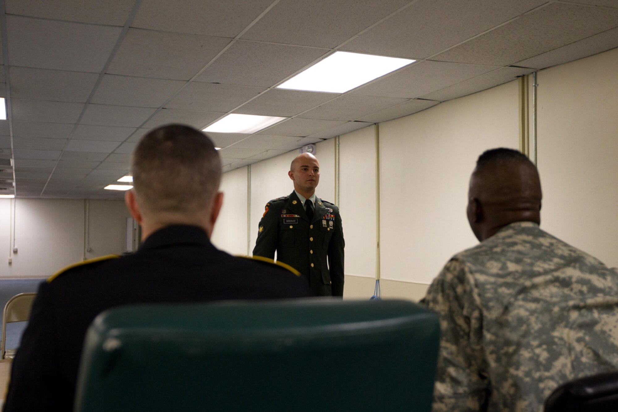 Sgt. Sergio Gonzalez, 725th Brigade Support Battalion, reports to command sergeants major David Turnbull, USARAK command sergeant major, and Charlie Lane, 3rd Maneuver Enhancement Brigade command sergeant major, April 14. The board was only a small part of the competition which decided USARAK NCO and Soldier of the Year. (U.S, Army photo/Staff Sgt. Brehl Garza)