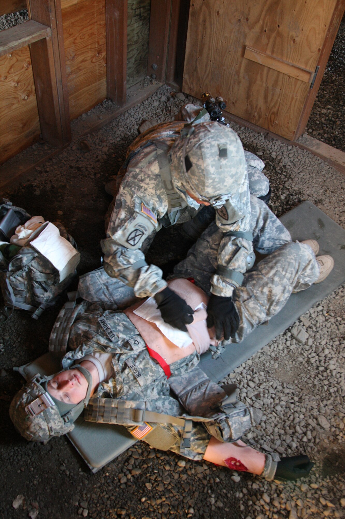 Army 1st. Lt. Edmund Carazo, A Co, 1/501st Inf Bn (Abn), applies an improvised dressing over an open abdominal wound during a first aid test station.  The dressing was applied in the correct sequence so as to not cause further injury to the Soldier. (U.S. Air Force photo/Percy Jones)