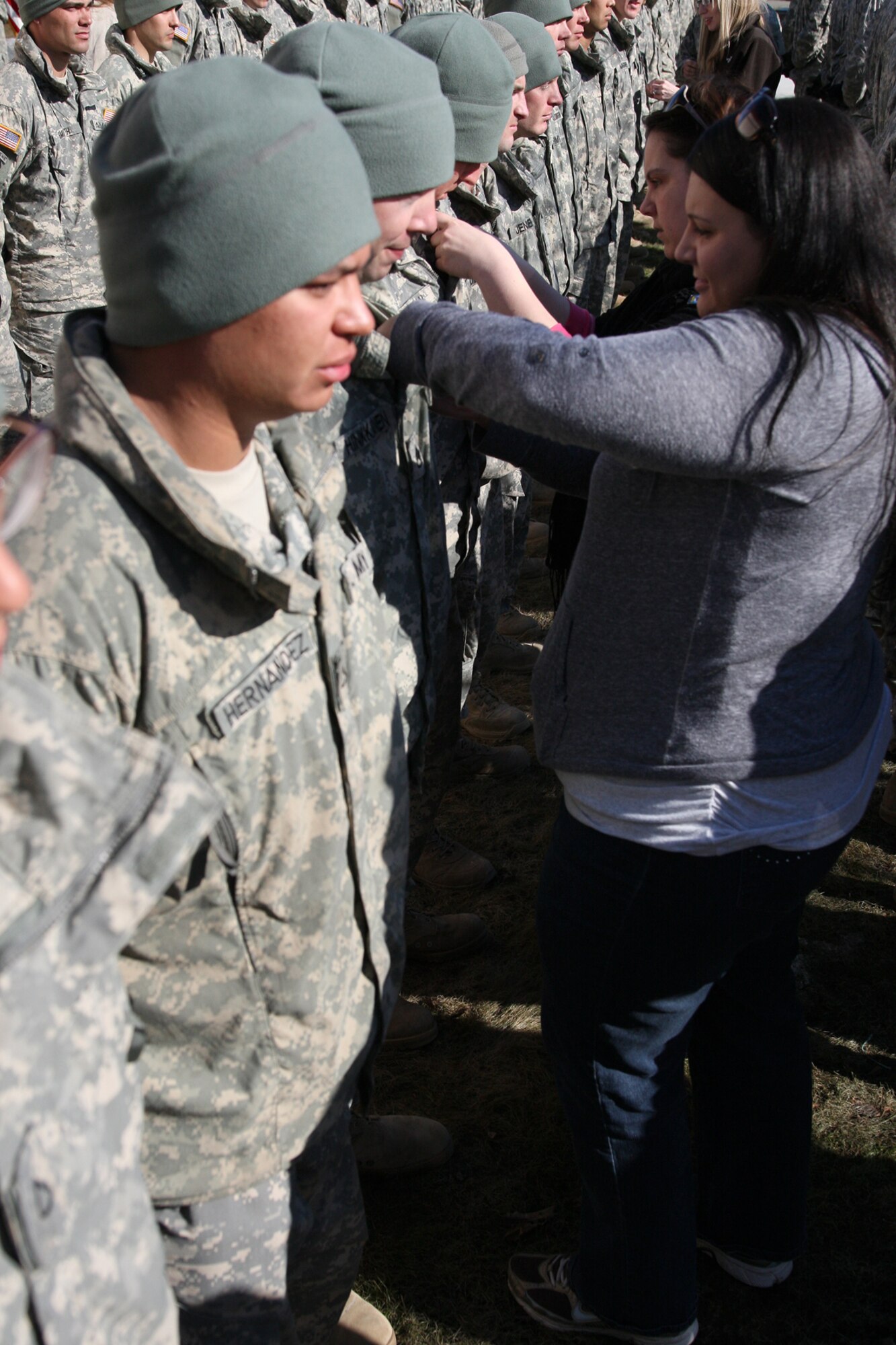 Family members of EIB awardess pin the coveted badge on their loved ones during the EIB ceremony.  Soldiers stood tall in formation after three grueling days of testing which culminated with a 12 mile, 35 lb ruck march. (U.S. Air Force photo/Percy Jones)