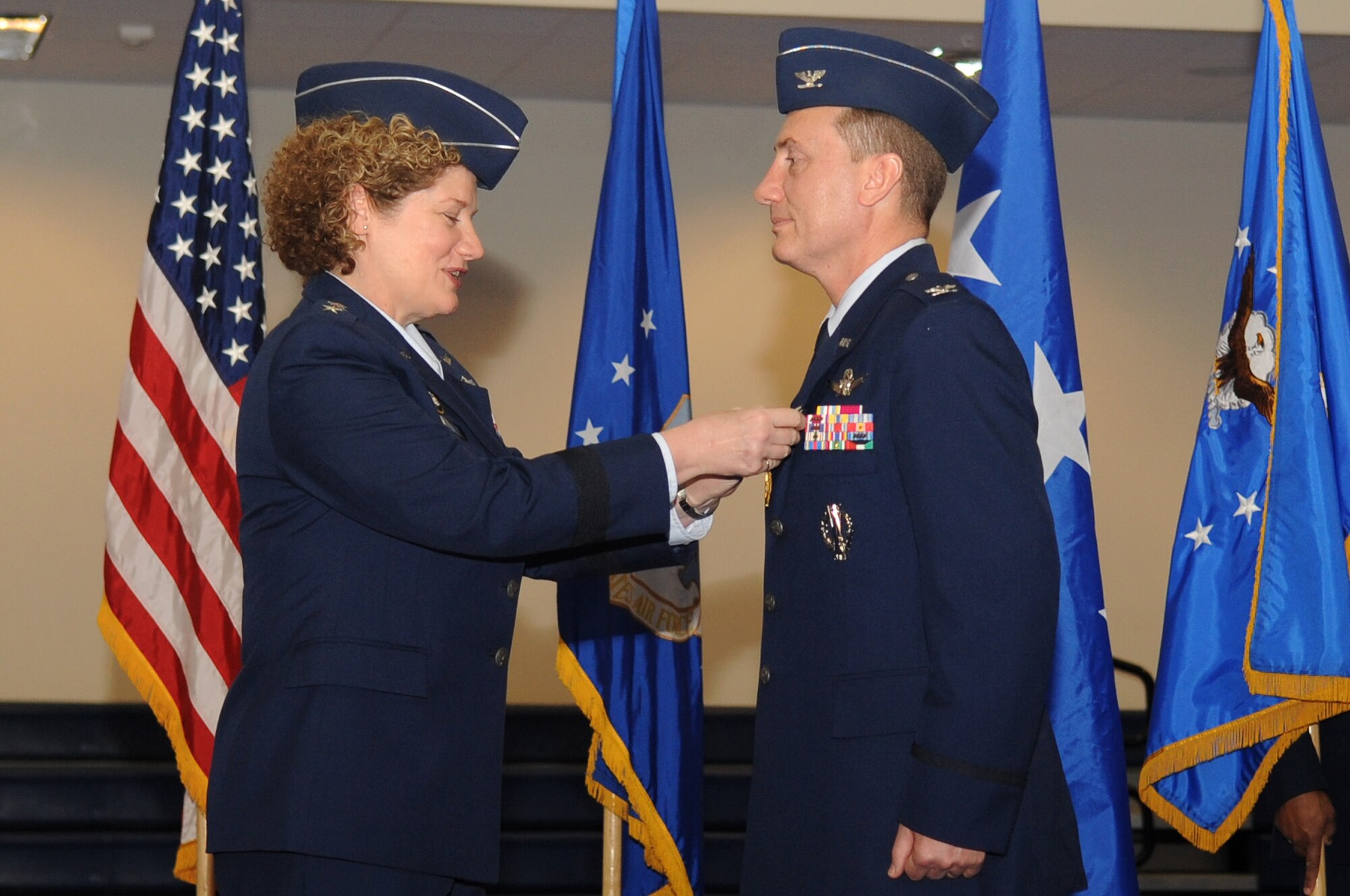 BUCKLEY AIR FORCE BASE, Colo.-- 14th Air Force Commander, Lt. Gen. Susan Helms, presents  the Legion of Merit to 460th Space Wing Commander, Col. Clint Crosier, April 25, 2011. Col. Crosier relinquished his command at Buckley Fitness Center. (U.S. Air Force photo by Airman Manisha Vasquez)