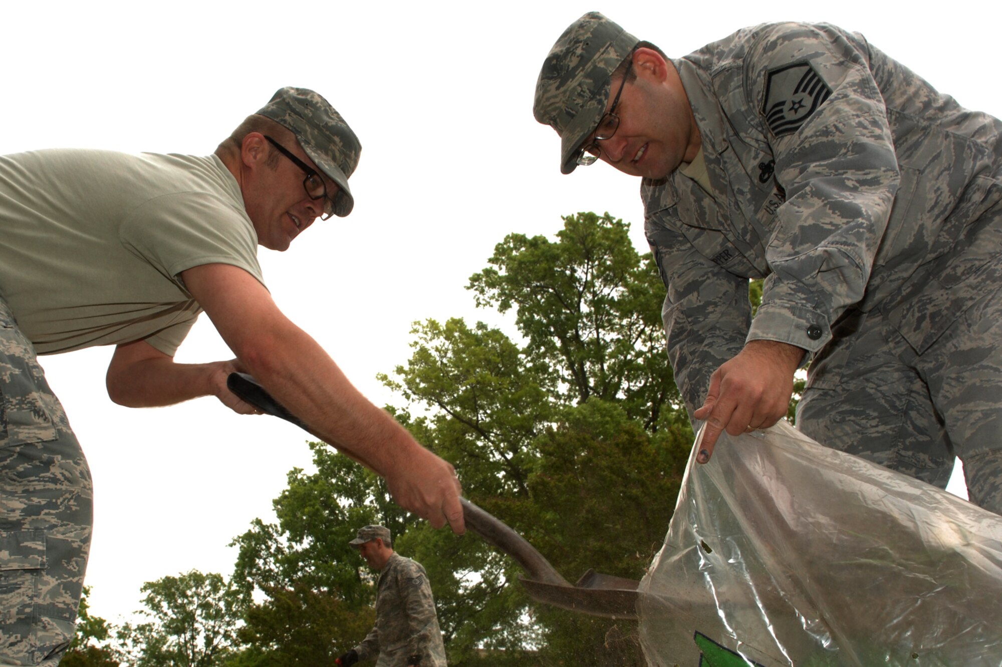 Master Sgts. Scott Azbell and Michael Skipper, Air Combat
Command, throw away grass and weeds to replace with mulch in a 
garden at Langley Air Force Base, Va., April 22, 2011. Langley
personnel participated in base clean-up during Earth Week, April 18-22. 
(U.S. Air Force photo by Staff Sgt. Jeff Nevison/Released)
