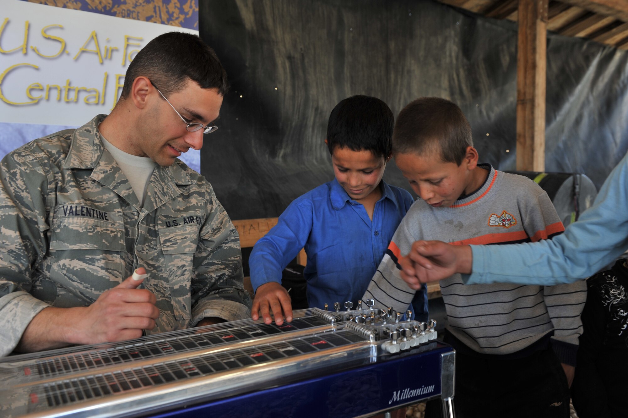 Tech. Sgt. Jeff Valentine, a U.S. Air Force Central Expeditionary Band steel guitarist and vocalist, allows Afghan children to play his instrument, April 20, 2011, at the Egyptian Field Hospital at Bagram Airfield, Afghanistan. (U.S. Air Force photo/Senior Airman Sheila deVera)