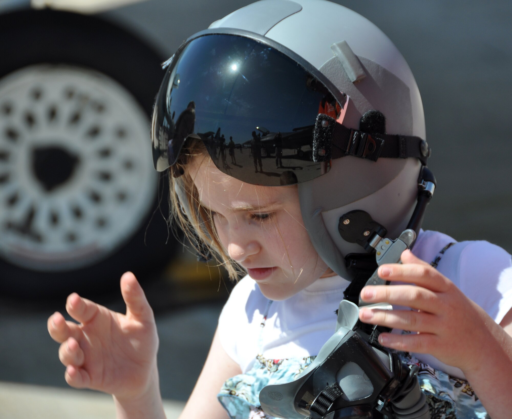 Rachel Hinsley tries on a helmet April 16 at the 2011 Air Expo held at Naval Air Station Fort Worth Joint Reserve Base, Texas.  More than 100,000 people were expected to visit the base each day of the two-day event.  (U.S. Air Force photo/Staff Sgt. Chris Bolen)