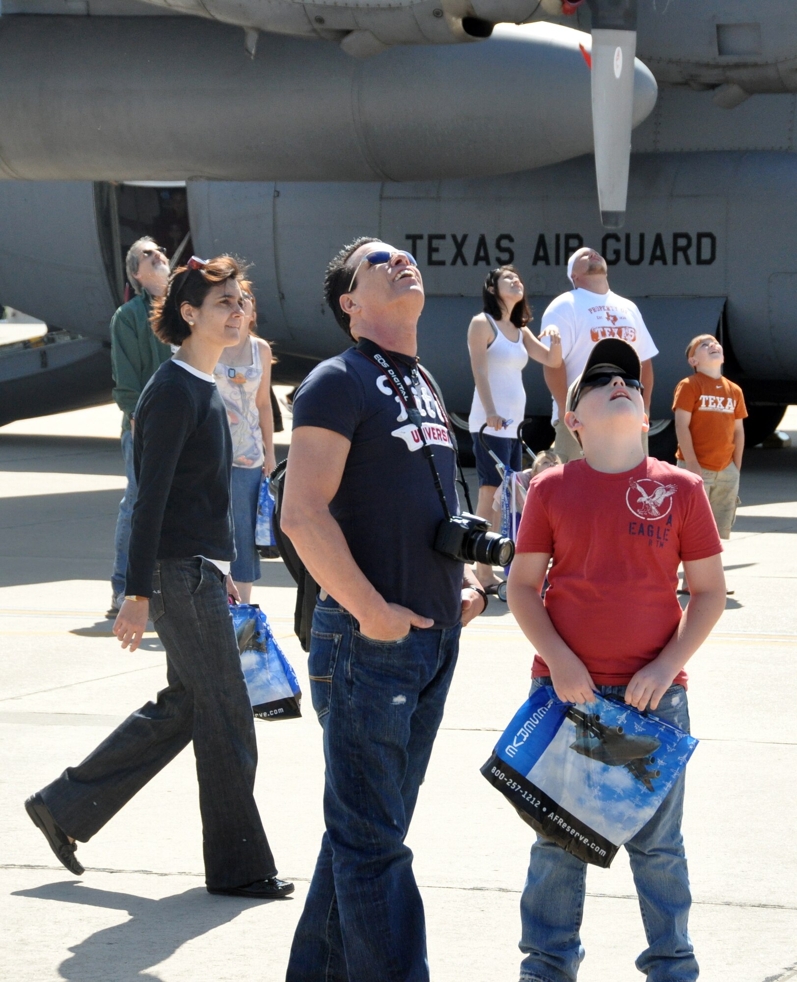 Glenn Parr, left, and Austin Ballard from Bonham, Texas, look skyward as the Special Operations Command parachute team begins its freefall set up at the start of the 2011 Air Power Expo at Naval Air Station Fort Worth Joint Reserve Base, Texas, April 16.  (U.S. Air Force photo/Staff Sgt. Chris Bolen)