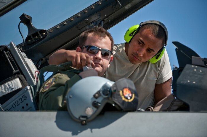 NELLIS AIR FORCE BASE, Nev. --  Airmen 1st Class Matthew Clayton. a crew chief from the 20th Aircraft Maintenance Squadron, Shaw Air Force Base, S.C.,  helps strap Capt. Brian Finkel a 79th Fighter Squadron, pilot into a F-16 Fighting Falcon for a training mission during exercise Green Flag West 11-6, April 20. Green Flag West replicates irregular warfare conditions currently found in Southwest Asia. Aircrews, work closely with Air Force joint terminal attack controllers. Pilots train for a missions such as close air support, and aerial reconnaissance. (U.S. Air Force photo by Tech. Sgt. Michael R. Holzworth)