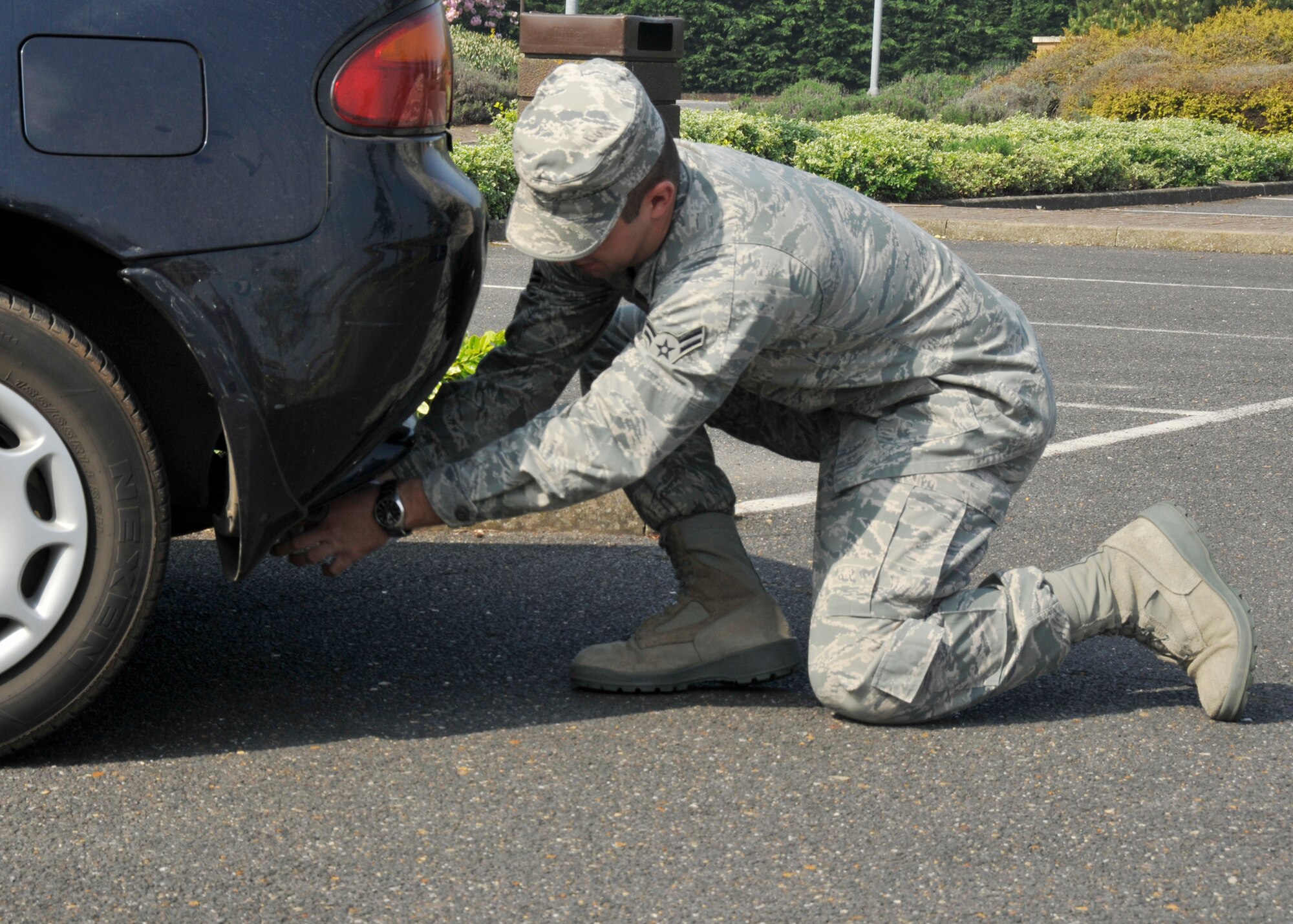 ROYAL AIR FORCE LAKENHEATH, England - Airman 1st Class Brooks Kimsey, 48th Contracting Squadron contract administrator, places a sock over the exhaust of a vehicle during the Dirty Sock Competition as part of Earth Week at Defender Park, April 20, 2011. A vehicle idles for two minutes while a sock is connected to the exhaust pipe to test the cleanliness of the vehicle. The winner received a voucher for a free car wash. (U.S. Air Force photo/ Senior Airman Tiffany M. Deuel)
