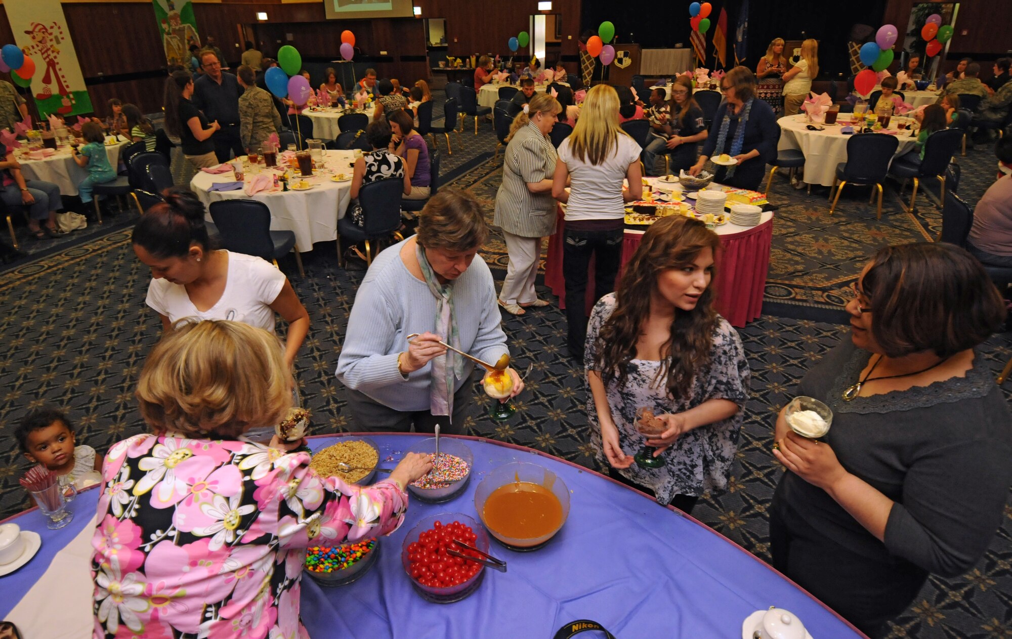 SPANGDAHLEM AIR BASE, Germany – Volunteers put toppings on ice cream during a 52nd Fighter Wing volunteer recognition ceremony at Club Eifel April 21. The ceremony was combined with an ice-cream social to thank wing volunteers for their efforts throughout the year. (U.S. Air Force photo/Staff Sgt. Benjamin Wilson)