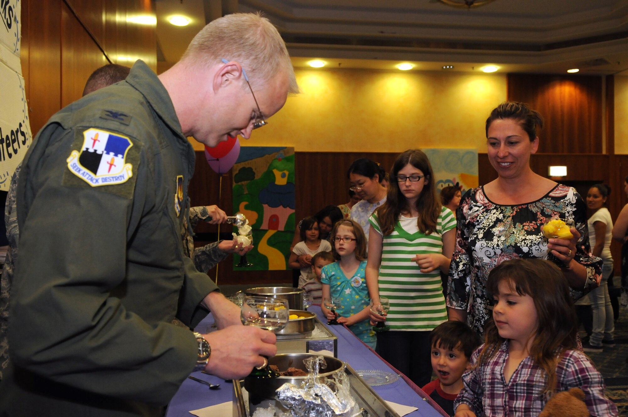 SPANGDAHLEM AIR BASE, Germany – Col. Christopher Weggeman, 52nd Fighter Wing commander, serves ice cream to volunteers and children during a 52nd FW volunteer recognition ceremony at Club Eifel April 21. The ceremony was combined with an ice-cream social to thank wing volunteers for their efforts throughout the year. (U.S. Air Force photo/Staff Sgt. Benjamin Wilson)