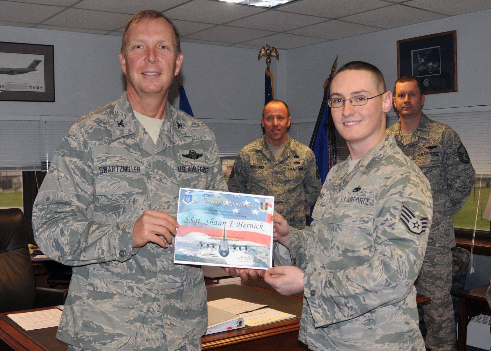 Staff Sgt. Shaun Hernick (right) receives an award from 914th Airlift Wing Commander  Col. Allan L. Swartzmiller April 22, 2011, Niagara Falls Air Reserve Station, NY. Staff Sgt. Hernick volunteered his services to the 914th Airlift Wing while waiting for transfer to Yokota Air Base, Japan. (U.S. Air Force photo by Staff Sgt. Joseph McKee)