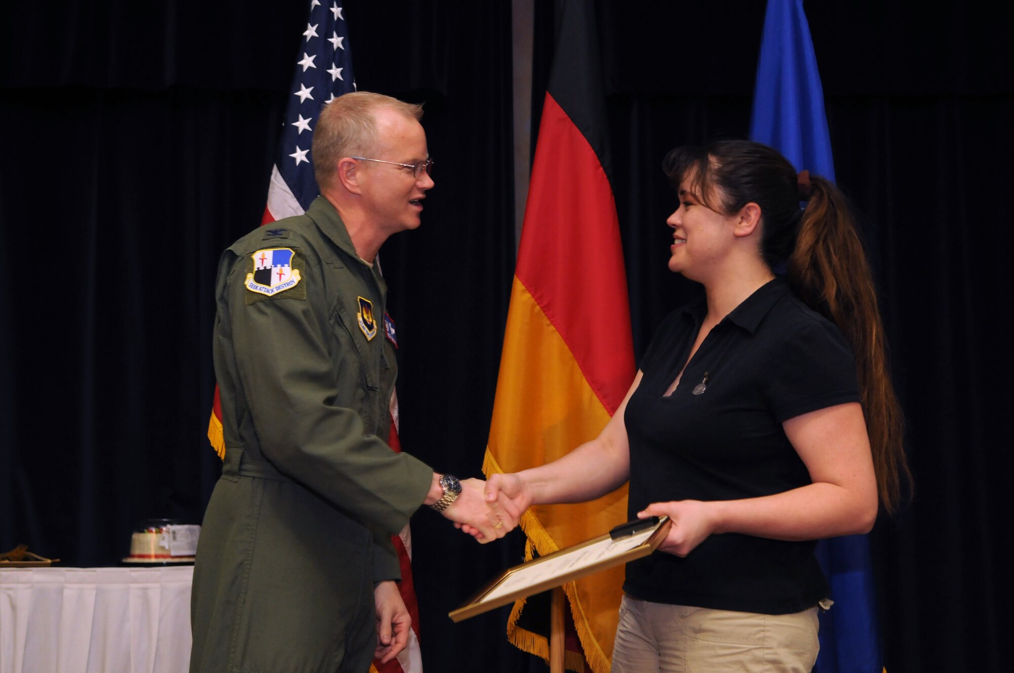 SPANGDAHLEM AIR BASE, Germany – Col. Christopher Weggeman, 52nd Fighter Wing commander, shakes hands with Heidi Woods after presenting her the volunteer achievement award during a 52nd FW volunteer recognition ceremony at Club Eifel April 21. The award was presented on behalf of the Chief of Staff of the Air Force and can only be awarded once a lifetime. (U.S. Air Force photo/Staff Sgt. Benjamin Wilson)