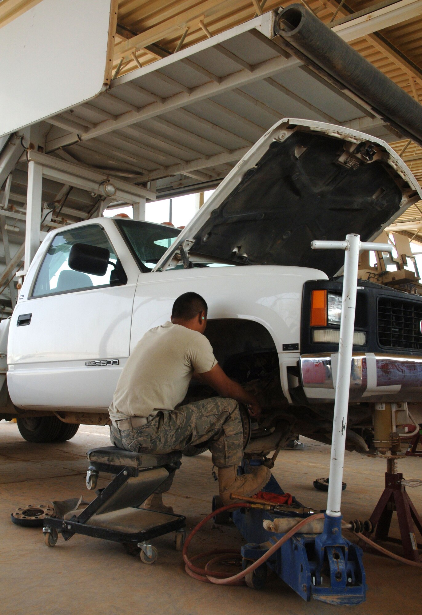 Senior Airman Greg Weiss, 532nd Expeditionary Operation Support Squadron Vehicle Maintenance Element mechanic and Lady Lake, Fla., native, works on the upper control arm of a staircase truck April 18, 2011, at Al Asad Air Base, Iraq. The vehicle maintenance element is responsible for maintaining a 68 vehicle fleet worth more than $18 million. Airman Weiss is deployed from Eglin Air Force Base, Fla. (U.S. Air Force photo by Staff Sgt. R. Michael Longoria/Released)