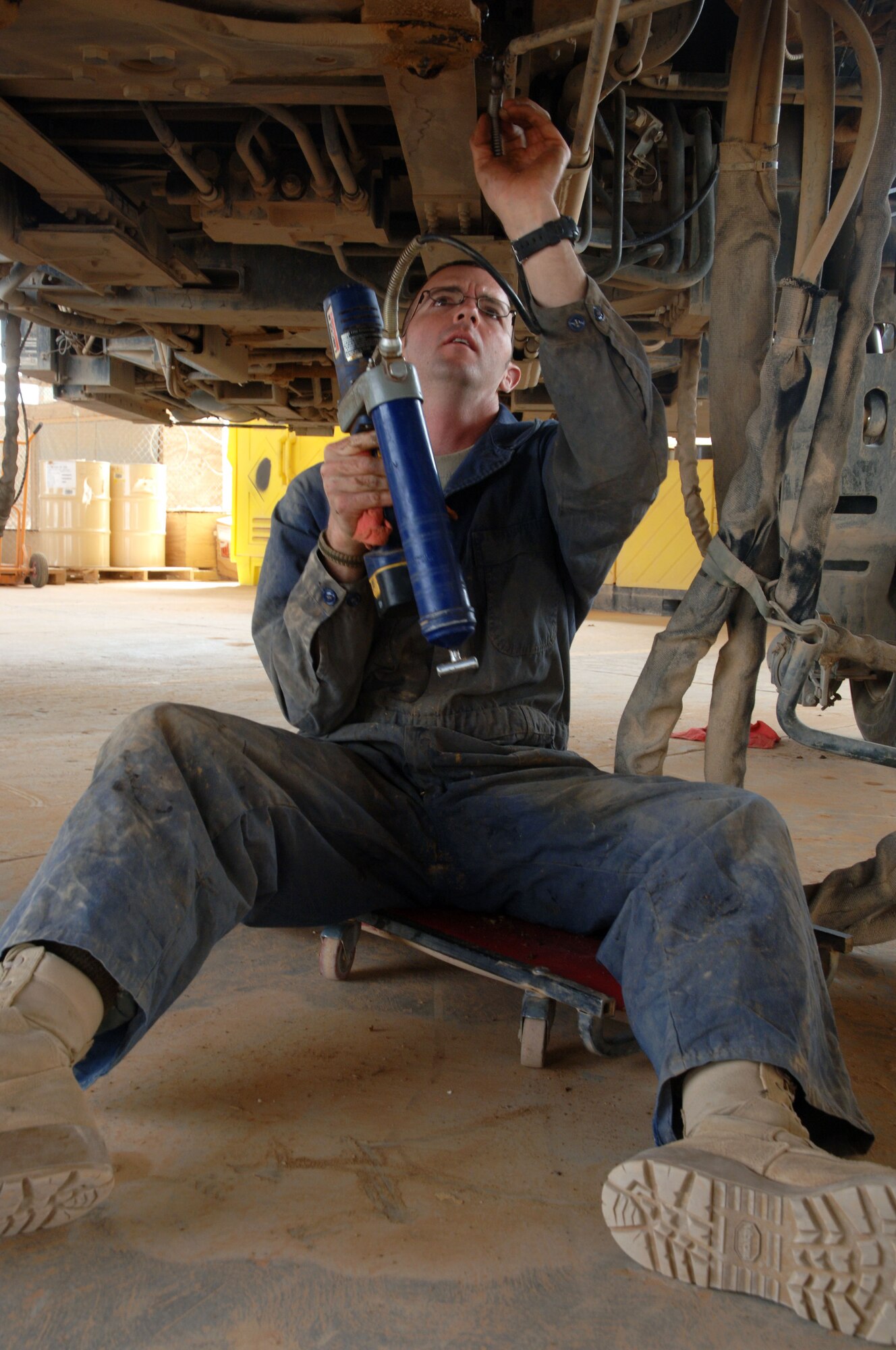 Staff Sgt. Todd Hickman, 532nd Expeditionary Operation Support Squadron Vehicle Maintenance Element mechanic and Auburndale, Fla., native, greases the joints on a 60K Cargo Loader April 18, 2011, at Al Asad Air Base, Iraq. The vehicle maintenance element is responsible for maintaining a 68 vehicle fleet worth more than $18 million. Sergeant Hickman is deployed from Seymour Johnson Air Force Base, N.C. (U.S. Air Force photo by Staff Sgt. R. Michael Longoria/Released)