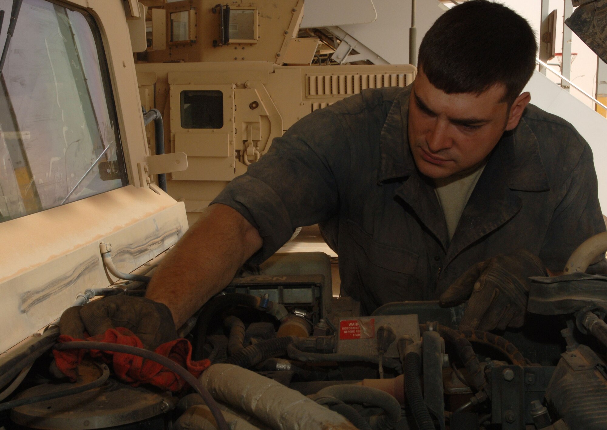 Staff Sgt. Chris Stamm, 532nd Expeditionary Operation Support Squadron Vehicle Maintenance Element mechanic and Canton, Ohio, native, tightens a cap after checking the power steering fluid on a humvee April 18, 2011, at Al Asad Air Base, Iraq. The vehicle maintenance element is responsible for maintaining a 68 vehicle fleet worth more than $18 million. Sergeant Stamm is deployed from Ramstein Air Base, Germany. (U.S. Air Force photo by Staff Sgt. R. Michael Longoria/Released)