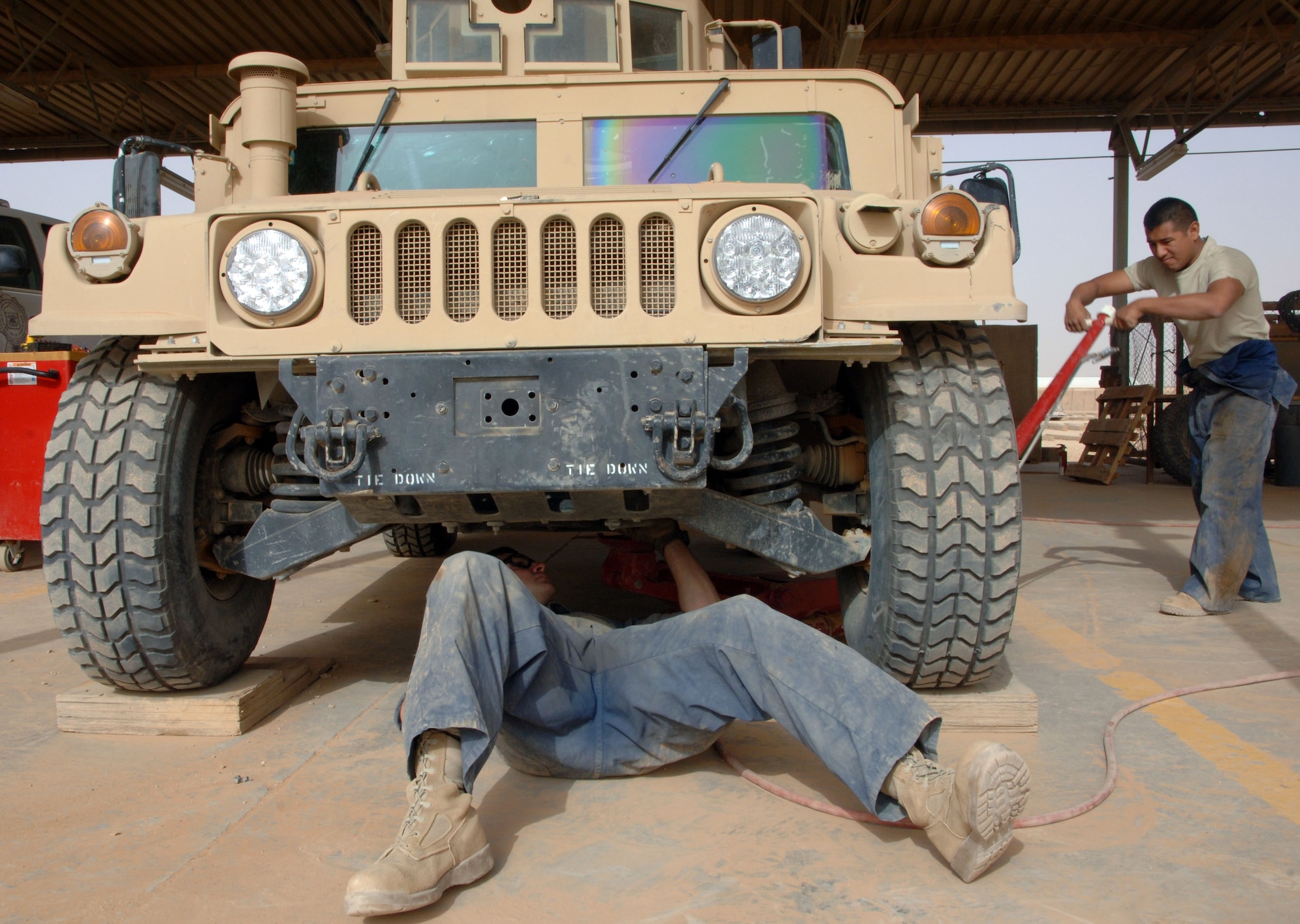 Senior Airman Greg Weiss (right), a Lady Lake, Fla., native, helps Staff Sgt. Chris Stamm, a Canton, Ohio, native, re-attach armor to a humvee after fixing its starter April 18, 2011, at Al Asad Air Base, Iraq. The mechanics are assigned to the 532nd Expeditionary Operation Support Squadron Vehicle Maintenance Element, which is responsible for maintaining a 68 vehicle fleet worth more than $18 million. (U.S. Air Force photo by Staff Sgt. R. Michael Longoria/Released)
