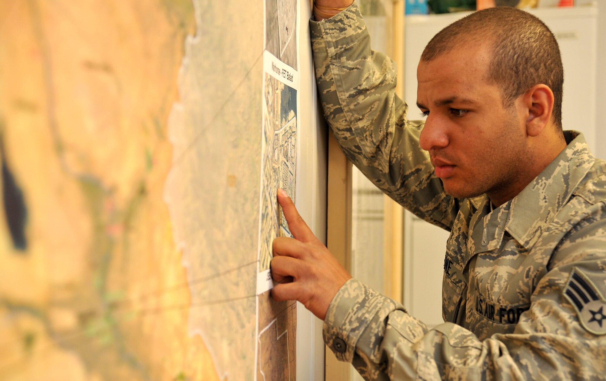 Senior Airman Michael Payne, a Facilities Engineer Team engineering assistant, looks closely at a map to make sure it is accurate April 13, 2011, at Contingency Operating Site Marez. The Marez team produces statements of work, plans and specifications for projects as well as surveying and mapping for several bases across Northern Iraq. Airman Payne is a St. Louis, Mo., native deployed from Charleston Air Force Base, S.C. (U.S. Air Force photo by Senior Airman Andrew Lee/Released)