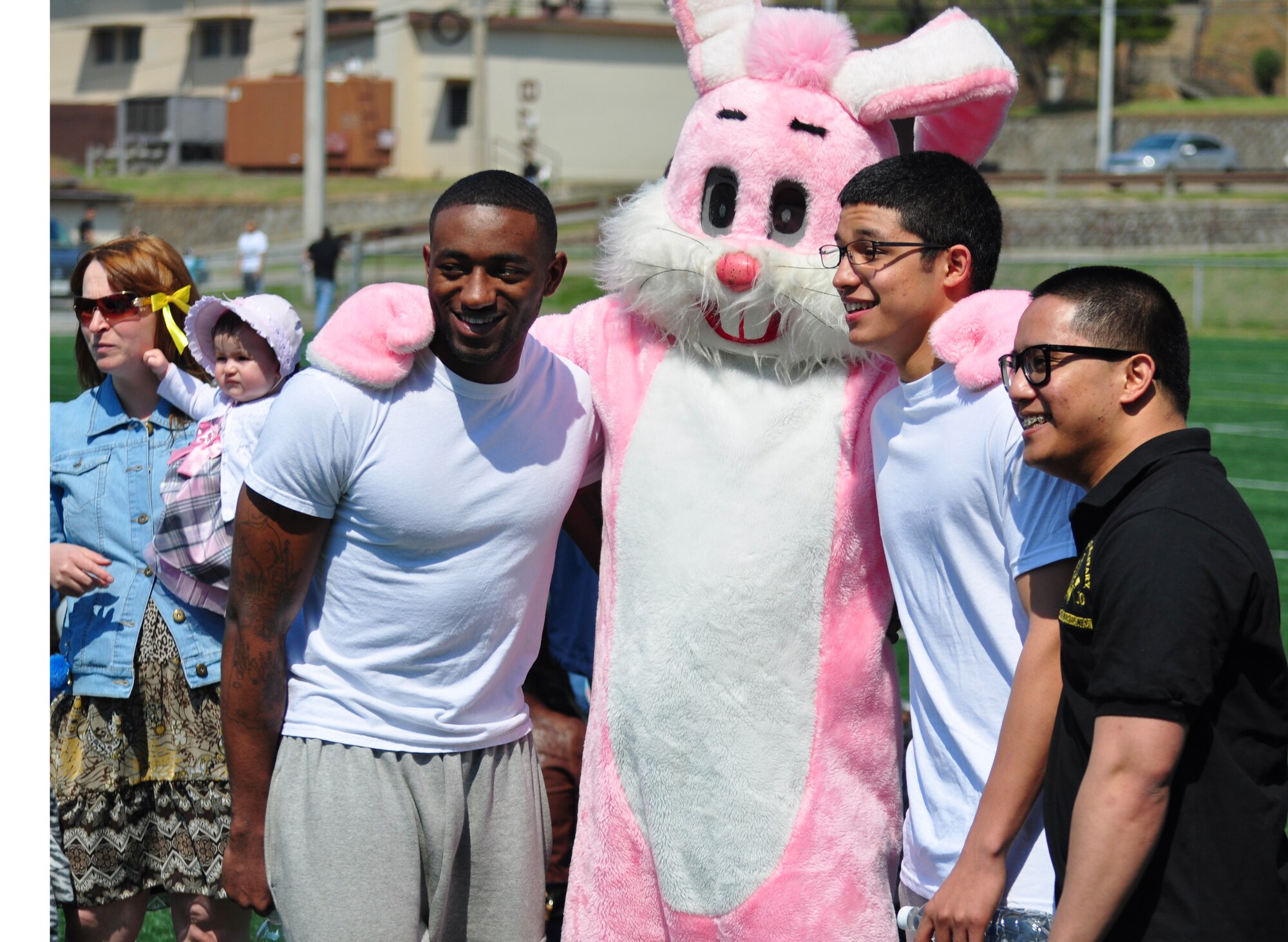 Some volunteers join in on the fun and pose for a photo with the Easter bunny at the base Easter egg hunt here April 23. More than 10,000 plastic eggs were placed around the field for children to pick up during the Easter egg hunt. (U.S. Air Force photo/Staff Sgt. Chad Thompson)
