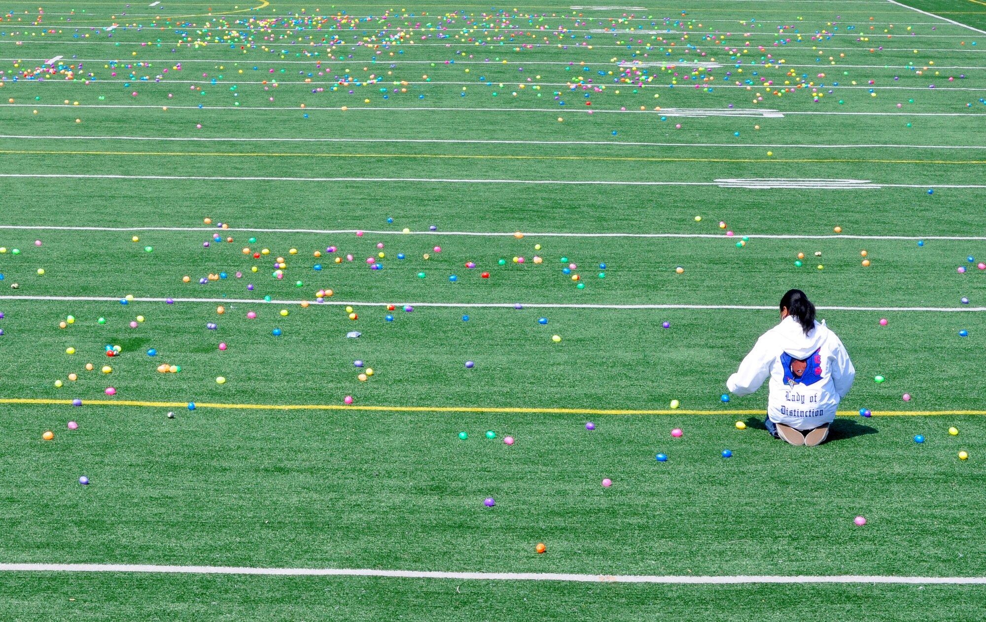 A volunteer hides golden tickets in random eggs for the base Easter egg hunt at the Osan High School football field April 23. More than 10,000 plastic eggs were placed around the Osan football field for children to pick up during the event. Osan celebrated Month of the Military Child and Child Abuse Prevention Month with the base Easter egg hunt and a parade from the Officers' Club to the Osan High School football field. (U.S. Air Force photo/Staff Sgt. Chad Thompson)