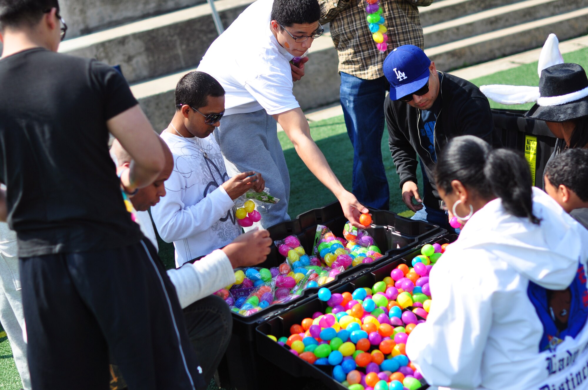 Volunteers unwrap plastic eggs near the Osan High School football field April 23 for the base Easter egg hunt. More than 10,000 plastic eggs were placed around the Osan football field for children to pick up during the event. Osan celebrated Month of the Military Child and Child Abuse Prevention Month with the base Easter egg hunt and a parade from the Officers' Club to the Osan High School football field. (U.S. Air Force photo/Staff Sgt. Chad Thompson)