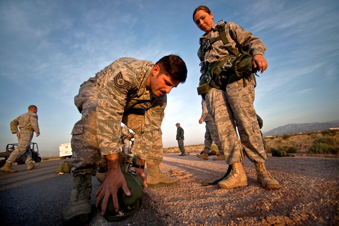 U.S. Air Force Tech. Sgt. Jose Gonzalez, left, inspects Staff Sgt. Emily Martin's parachute before a training jump on Nellis Air Force Base, Nev., April 15, 2011. Gonzalez, an airborne fuels and utilities craftsman, and Martin, an airborne emergency management craftsman, are assigned to the 820th Red Horse Squadron.