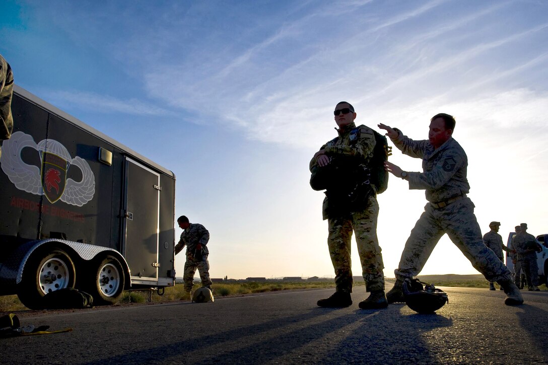 U.S. Air Force Master Sgt. Philip Nicholson, right, inspects Staff Sgt. Benjamin Johnis' parachute before a training jump on Nellis Air Force Base, Nev., April 15, 2011. Nicholson, the airborne noncommissioned officer in charge, is assigned to the 820th Red Horse Squadron. Johnis is an survive, evade, resist and extract specialist assigned to the 414th Combat Training Squadron.