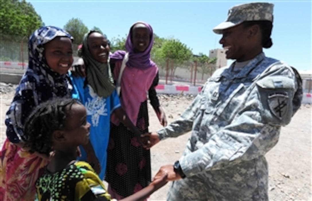 U.S. Army Capt. Courtney Sanders (right), with the 402nd Civil Affairs Battalion, laughs with a group of girls in front of the Dikhil High School in Dikhil, Djibouti, on April 19, 2011.  The Battalion was working on renovating the school.  The project, which began April 16, is scheduled to refurbish six classrooms, the school's roof and an office.  