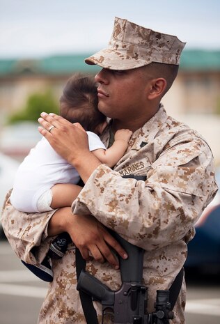 Cpl. Antonio Tellez, an administrative clerk with Headquarters Battery, 1st Battalion, 12th Marine Regiment, holds his 3-month-old son before departing Marine Corps Base Hawaii on a seven-month deployment to Afghanistan in support of Operation Enduring Freedom, April 25, 2011. Over the course of the week, approximately 550 Marine and sailors from 1/12 left Hawaii to replace 1st Battalion, 10th Marine Regiment, in Afghanistan’s Helmand province. Unlike their last two deployments — supporting Task Forces Military Police in Iraq — 1/12 will revert back to its primary mission and provide artillery fire support to 2nd Marine Division (Forward) during ongoing counterinsurgency operations in the province.