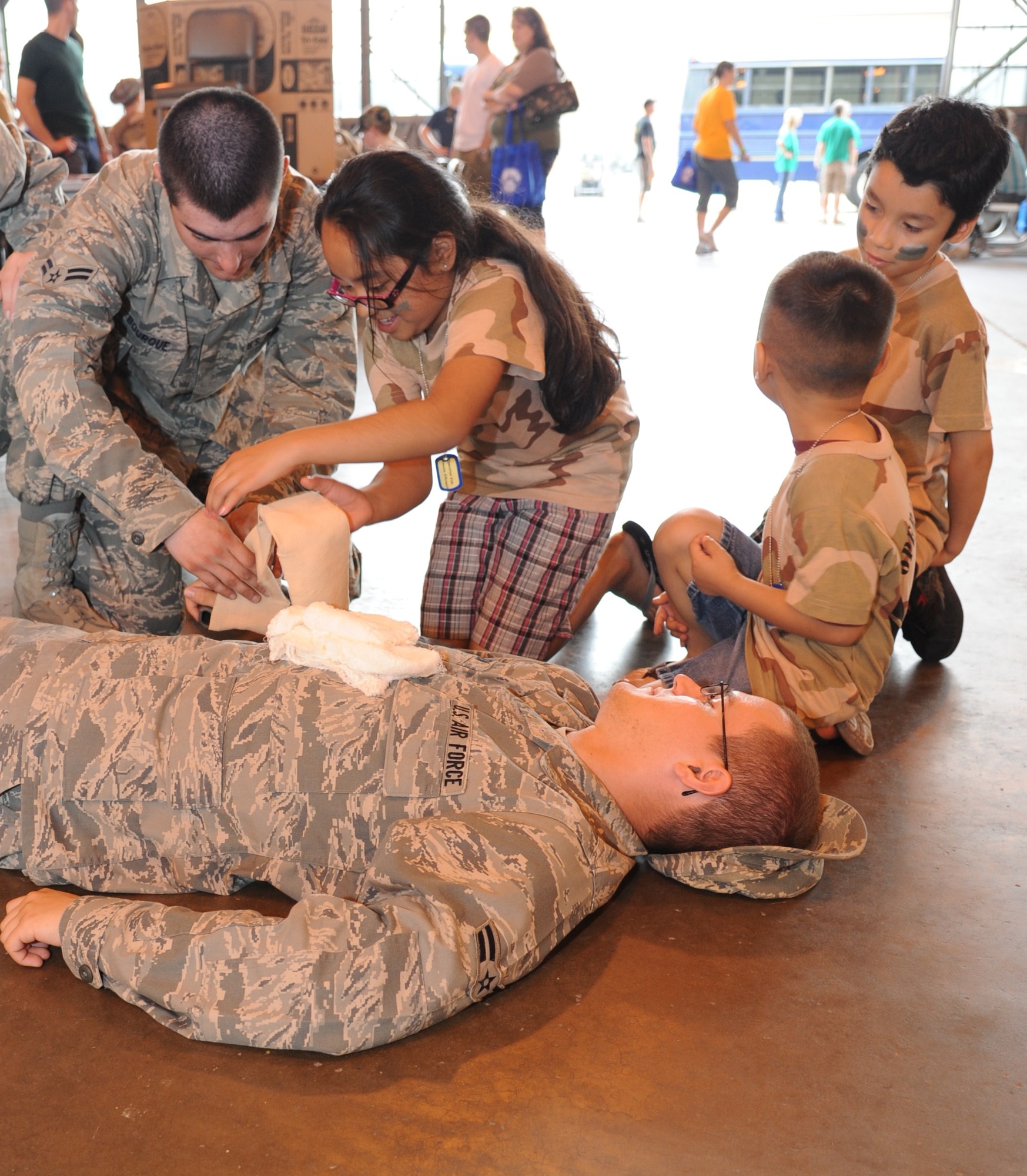 Children are shown how to use medical equipment to dress a wound for an injured Airman during the annual Operation KIDS event, April 23. The event is designed to help children in military families understand and experience the processes their parents go through during deployments. (U.S. Air Force Photo/Airman 1st Class Adawn Kelsey)