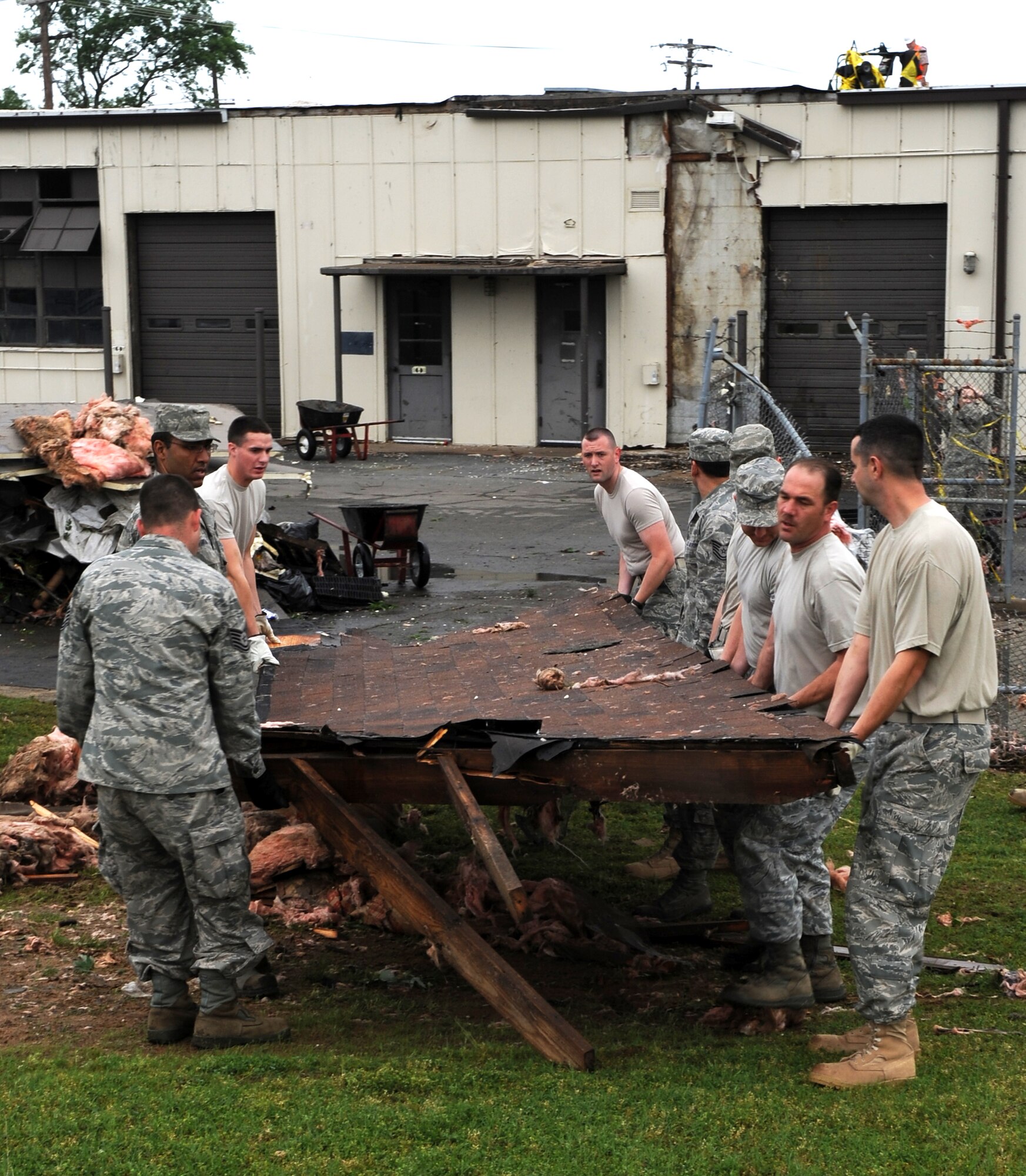 Airmen work together in an effort to clear debris April 26, 2011, at Little Rock Air Force Base, Ark., after a tornado struck the base at approximately 8 p.m. April 25. Little Rock AFB sustained significant damage to base housing, the base exchange, fire department and buildings along the flightline. (U. S. Air Force photo by Airman 1st Class Rusty Frank)