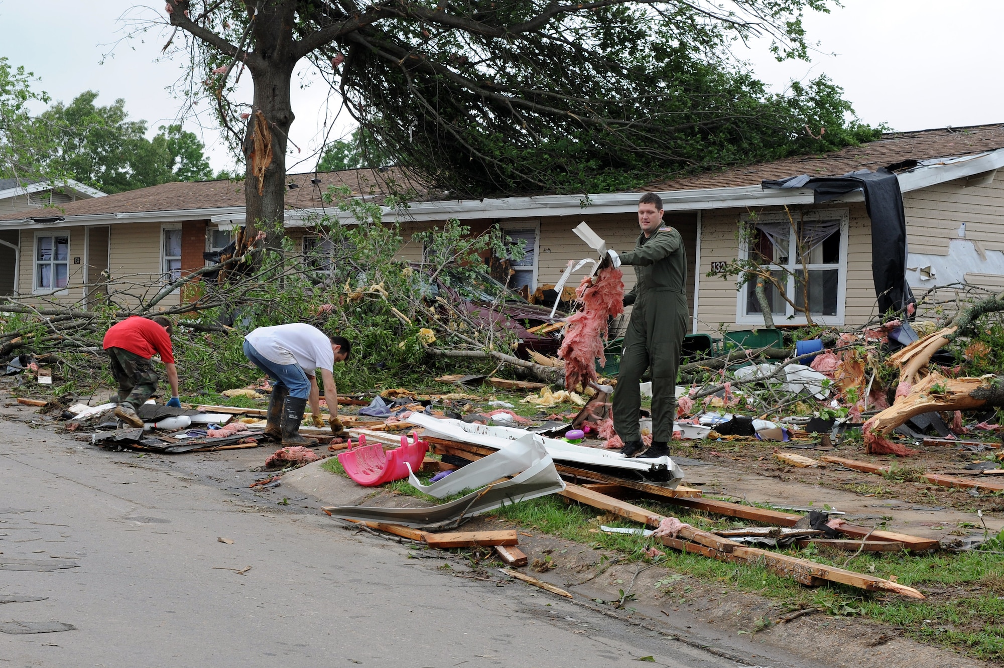 Airmen and family members work to clear debris from base housing after a tornado struck April 25, 2011, at Little Rock Air Force Base, Ark. Several families were relocated from damaged homes to base billeting. (U. S. Air Force photo by Airman 1st Class Ellora Stewart)