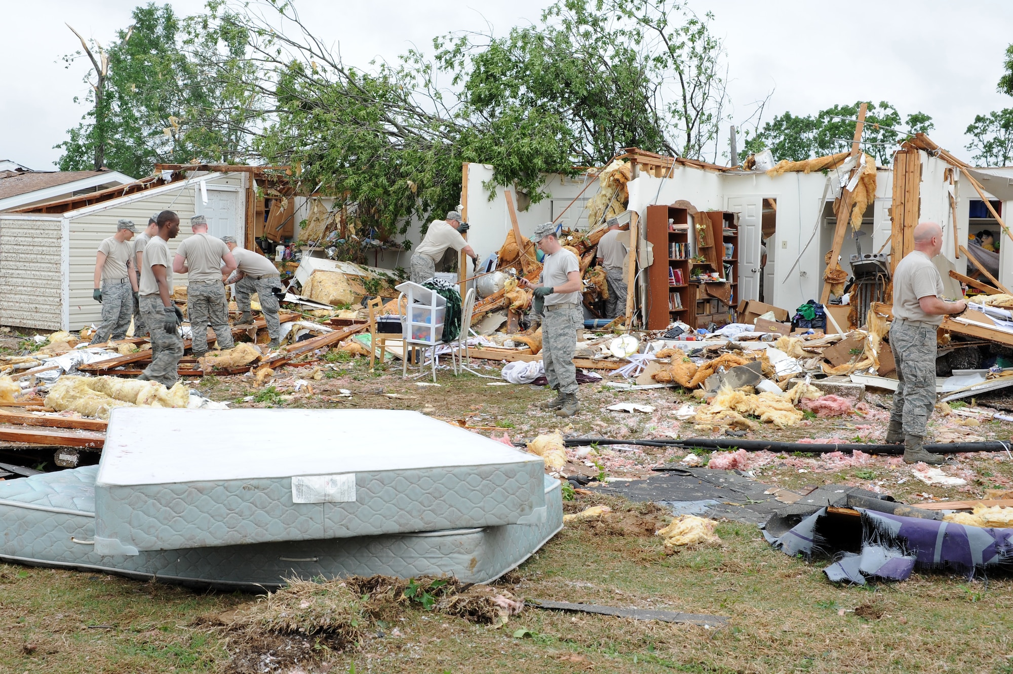Airmen and family members work to clear debris from base housing after a tornado struck April 25, 2011, at Little Rock Air Force Base, Ark. Several families were relocated from damaged homes to base billeting. (U. S. Air Force photo by Airman 1st Class Ellora Stewart)