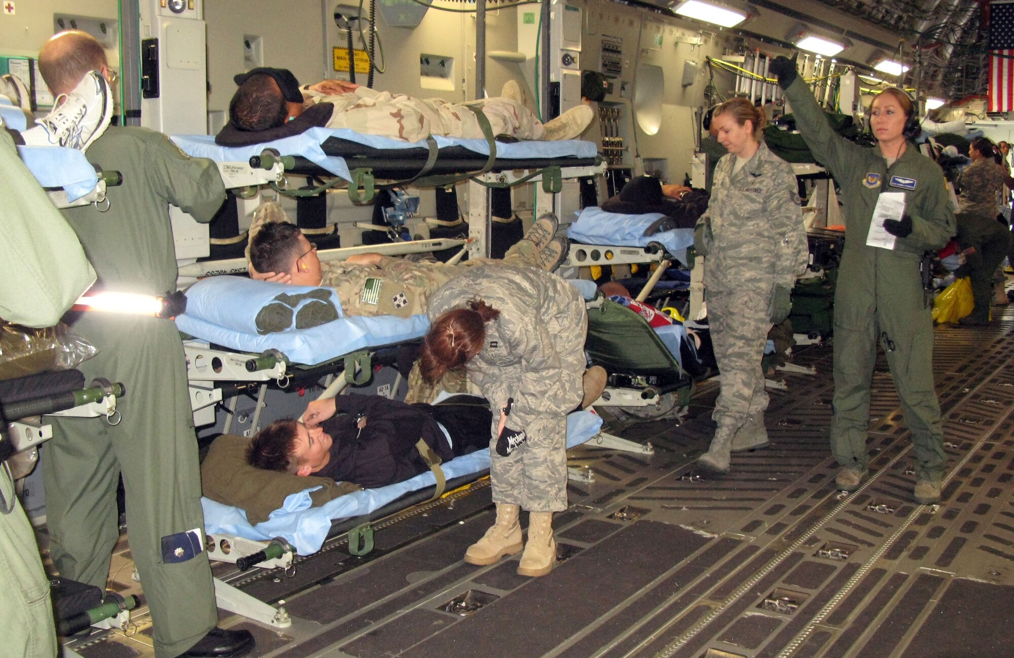 An aeromedical evacuation crew makes final checks on wounded warriors aboard a C-17 Globemaster III aircraft at Ramstein Air Base, Germany, before an April 26, 2011, flight to Andrews Air Force Base, Md., to receive advanced-level care in the United States. (Defense Department photo/Donna Miles )