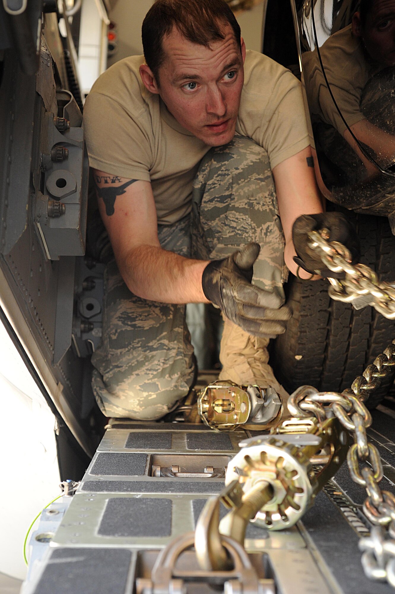 U.S Air Force Reserve Tech. Sgt. Joshua Warbiany, 86th Aerial Port Squadron, Joint Base Lewis-McChord, Wash., secures with chains an 11-meter rigid-hulled inflatable boat from U.S. Navy Special Boat Team 12 to transport in a C-17 Globemaster III, at North Island Naval Air Station, Calif., April 14, 2011, in support of Patriot Hook 2011. Patriot Hook is an annual Air Force Reserve Terminal Airlift Control Element exercise simulating a joint force response to a natural disaster in a forward deployed location. The exercise deploys three TALCE units and brings together units of the Air Force Reserve, Navy, Department of Homeland Security and other federal agencies. (U.S. Air Force photo by Tech. Sgt. Christine Jones)
