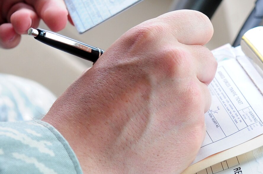 Staff Sgt. Robert O’Neill, 2nd Security Forces Squadron, writes an Armed Forces Traffic Ticket for an individual he pulled over during his patrol on Barksdale Air Force Base, La., April 26. During patrol, Sergeant O’Neill is on the look-out for traffic violations including speeding and running stop signs and individuals who neglect to use hands-free cellular devices. (U.S. Air Force photo/Senior Airman Joanna M. Kresge)