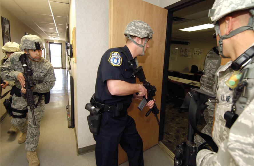 In a security forces building, Tinker 72nd Security Forces Squadron military and Department of Defense police train for responding to active shooter scenarios. (Air Force photo by Margo Wright)