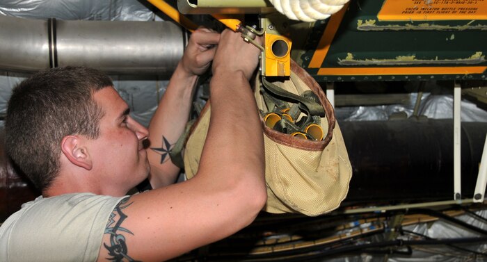 Airman 1st Class Eric Duncan removes a coiled rope ladder to reach the attached 46-person life raft from the inside of a C-17 April 25, on Joint Base Charleston - Air Base. The ladder is triggered by a Flotation Equipment Deployment System in case of an emergency. Airman Duncan is a crew chief from the 437th Aircraft Maintenance Squadron. (U.S. Air Force photo by /Airman 1st Class Jared Trimarchi)
