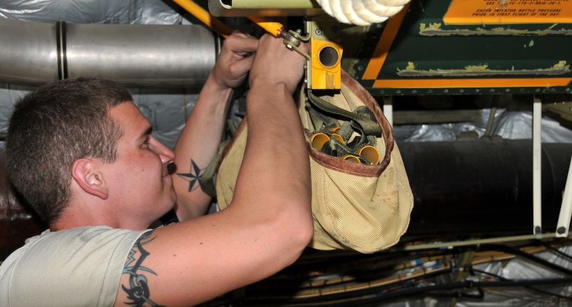 Airman 1st Class Eric Duncan removes a coiled rope ladder to reach the attached 46-person life raft from the inside of a C-17 April 25, on Joint Base Charleston - Air Base. The ladder is triggered by a Flotation Equipment Deployment System in case of an emergency. Airman Duncan is a crew chief from the 437th Aircraft Maintenance Squadron. (U.S. Air Force photo by /Airman 1st Class Jared Trimarchi)
