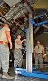 Senior Airman David Torres (left), Airman 1st Class Eric Duncan (middle) and Staff Sgt. Jessy Martin use a Genie lift to lower a 46-person life raft from the inside of a C-17 April 25, on Joint Base Charleston - Air Base. Each C-17 carries three life rafts that must be replaced every three years. Airman Torres, Airman Duncan and Sergeant Martin are crew chiefs from the 437th Aircraft Maintenance Squadron. (U.S. Air Force photo by /Airman 1st Class Jared Trimarchi)