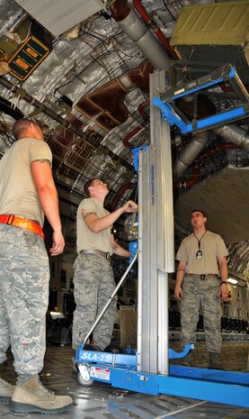 Senior Airman David Torres (left), Airman 1st Class Eric Duncan (middle) and Staff Sgt. Jessy Martin use a Genie lift to lower a 46-person life raft from the inside of a C-17 April 25, on Joint Base Charleston - Air Base. Each C-17 carries three life rafts that must be replaced every three years. Airman Torres, Airman Duncan and Sergeant Martin are crew chiefs from the 437th Aircraft Maintenance Squadron. (U.S. Air Force photo by /Airman 1st Class Jared Trimarchi)
