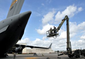 William Rigdon (right) and Senior Airman Charles Barnes, hydraulic technicians from the 437th Aircraft Maintenance Squadron, ride a high reach lift, or Condor, to the tail of a C-17 April 25, on Joint Base Charleston - Air Base. The technicians were thoroughly inspecting the Integrated Flight Control module. Airman Barnes is part of the 437 AMXS team Gold and Mr. Rigdon is part of team Blue. (U.S. Air Force photo by /Airman 1st Class Jared Trimarchi)

