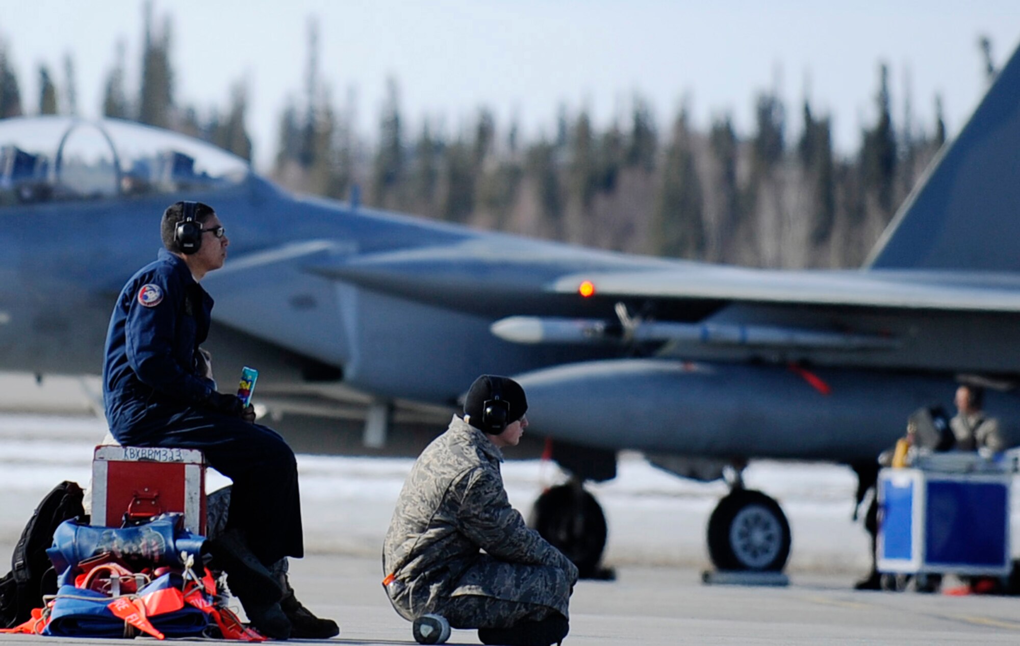 Airman 1st Class Orlando Nastacio and Senior Airman Matthew Remick take a break before marshalling  an F-15 Eagle during RED FLAG-Alaska 11-1 April 20, 2011, Eielson Air Force Base, Alaska. RF-A is a Pacific Air Forces-directed field training exercise for United States and allied forces to train under simulated air-combat situations. Airmen Nastacio and Remick are crew chiefs assigned to the 18th Aircraft Maintenance Squadron, Kadena Air Base, Japan. (U.S. Air Force photo/Airman 1st Class Laura Goodgame)