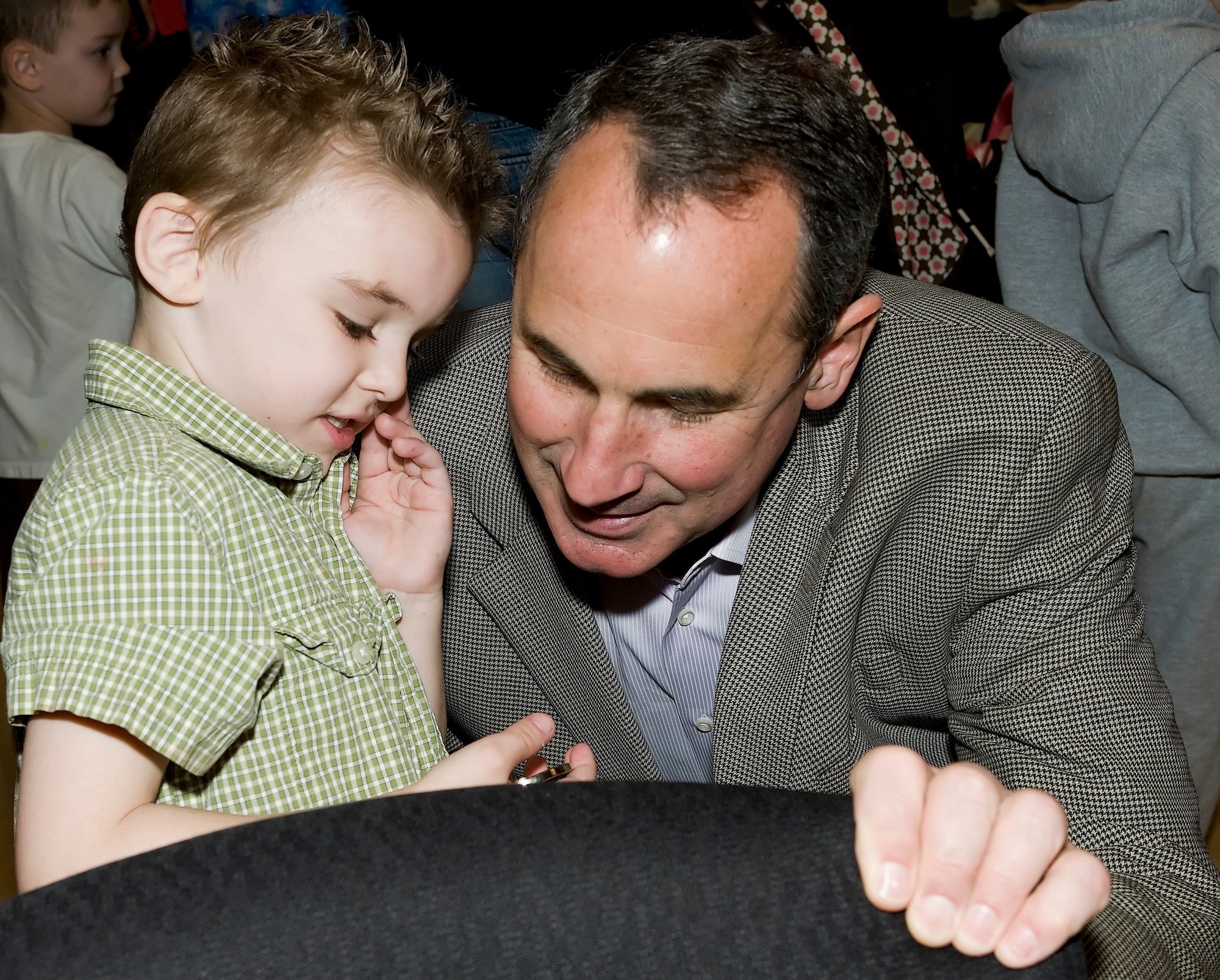 Gen. Raymond Johns, Air Mobility Command commander, presents a coin to Noah Allen April 21, 2011, at the Deployed Spouses Dinner at Dover Air Force Base, Del. Gen. Johns made the appearance to support the families of deployed servicemembers such as Noah’s father, Senior Airman James Allen. (U.S. Air Force photo by Airman 1st Class Samuel Taylor)  