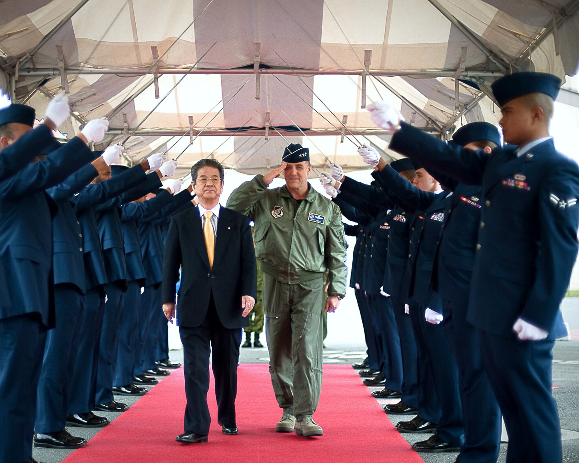 Toshimi Kitazawa and Lt. Gen. Burton Field walk through an honor guard cordon April 23, 2011, at Yokota Air Base, Japan. Minister Kitazawa visited Yokota AB to thank U.S. service members for their efforts in support of Operation Tomodachi and to observe a bilateral demonstration of the U.S. Marine's and Japan Ground Self-Defense Force chemical response forces. Mr. Kitazawa is the Japan Minister of Defense and General Field is the U.S. Forces Japan and 5th Air Force commander. (U.S. Air Force photo/Staff Sgt. Chad C. Strohmeyer)