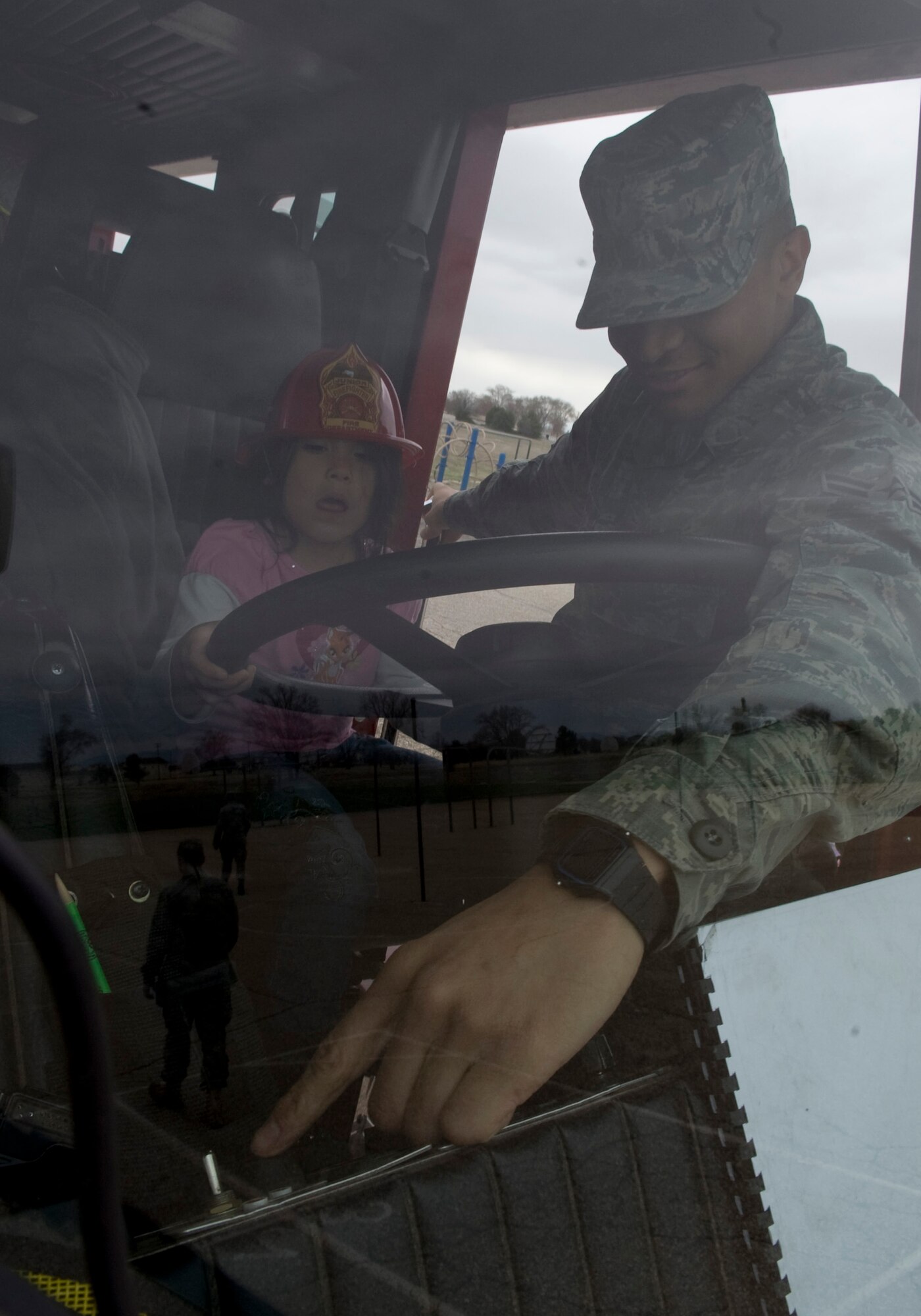 MOUNTAIN HOME AIR FORCE BASE, Idaho -- Airman 1st Class Ladarius McCoy, 366th Civil Engineer Squadron firefighter, explains switches on a P-24 Pumper to seven-year-old Tehya Hernandez, daughter of Senior Airman Rolando Hernandez, 366th Component Maintenance Squadron, during the Base Primary Carnival here April 15. Gunfighters attend the carnival to raise funds to support the Liberty Elementary School during the school year.  (U.S. Air Force photo by Staff Sgt. Roy Lynch)